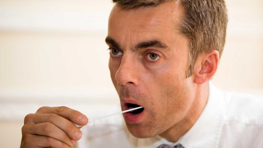 A man performs a cheek swab for genetic testing