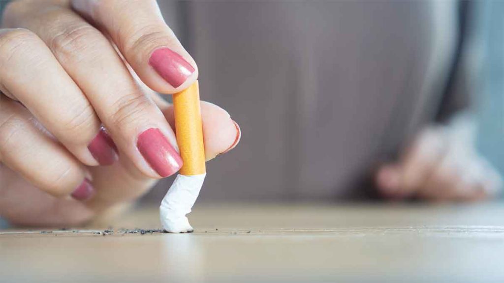 Hand crushing a cigarette on a table