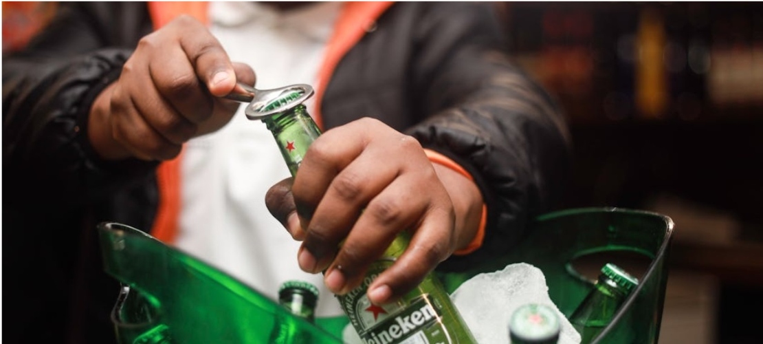 A man opening a beer bottle.