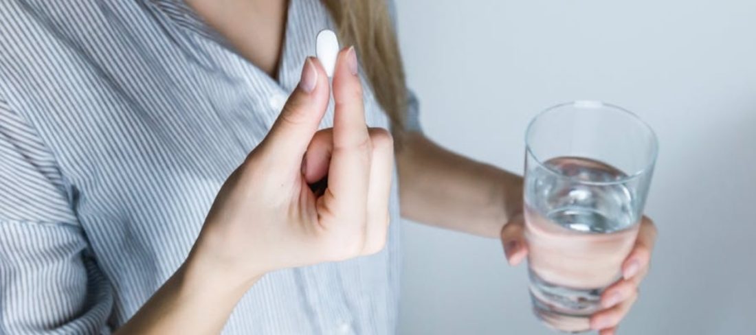 A woman taking a pill