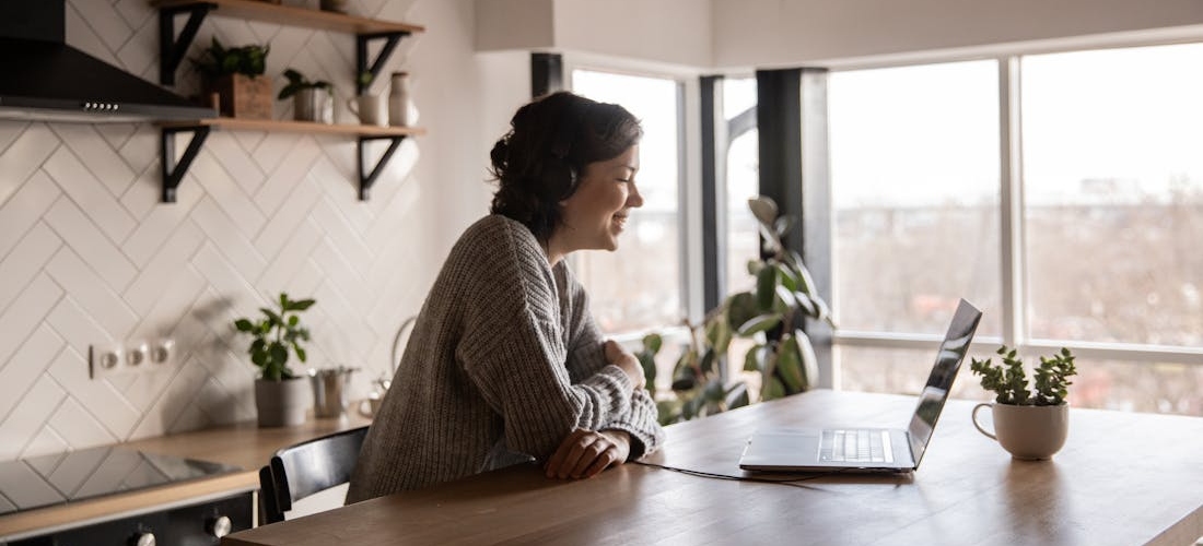 A person smiling while attending an online session and learning how to cope with hangxiety